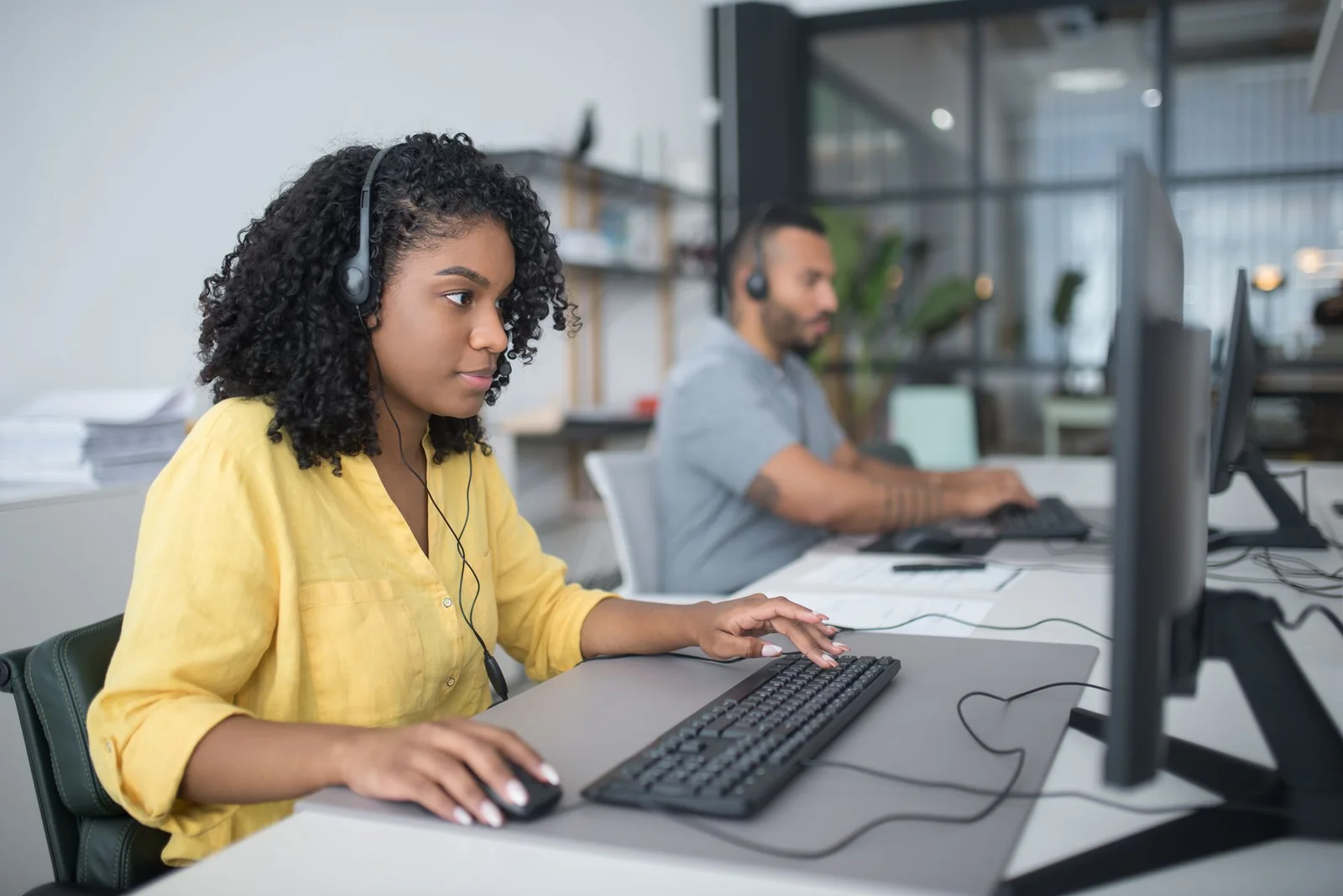 Customer communication staff using headsets and desktop computers